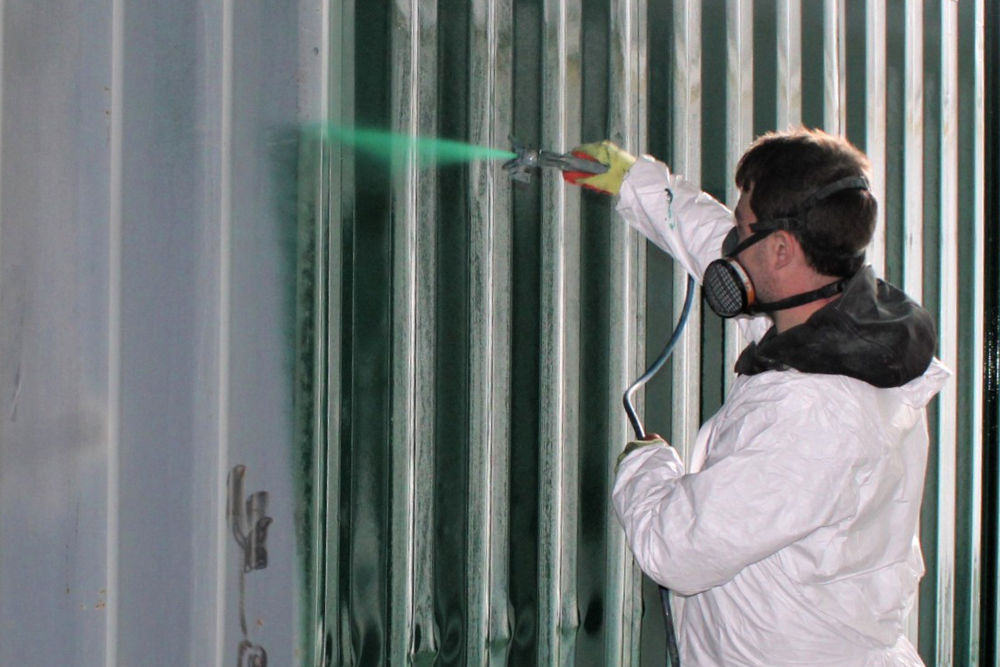 repainting a shipping container in action